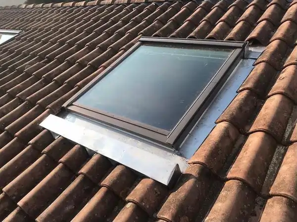 Pose d'un Velux neuf avec raccord zinc sur toiture tuiles rouges